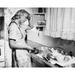 Side profile of a young woman washing utensils in the kitchen Poster Print (18 x 24)