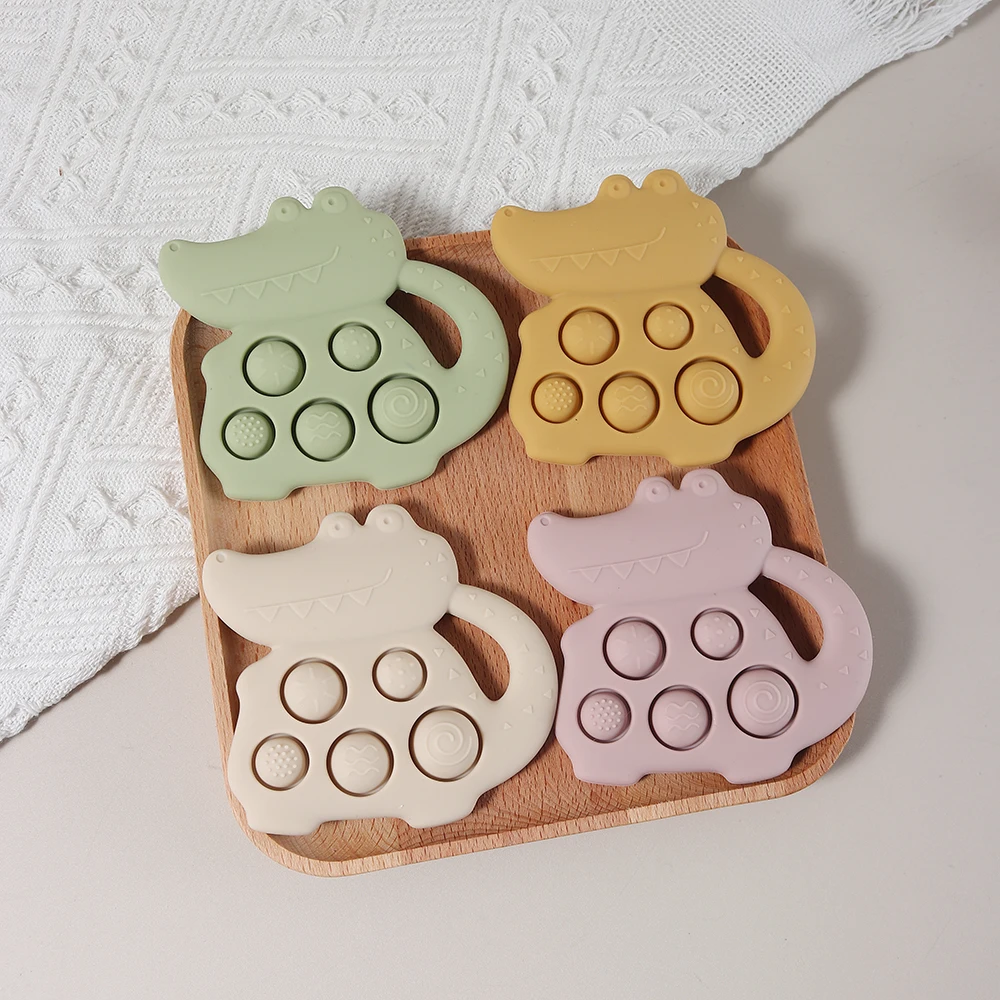 Krokodil-Beißring und sensorisches Pressspielzeug aus lebensmittelechtem Silikon – sicher und lustig für Babys. Ungiftiges, lebensmittelechtes Silikon für die Zähne Image