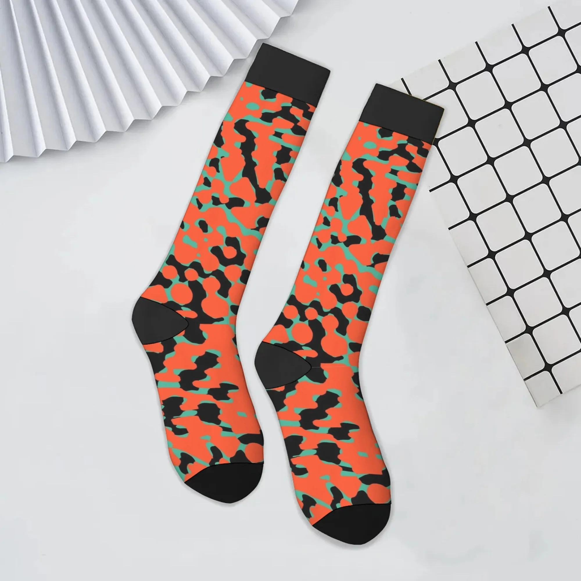 Lebendige, farbblockierende Kniestrümpfe mit orangefarbenen Basis, scharfen schwarzen Streifen und blaugrünen geometrischen Formen für den High-Energy-Street-Style Image