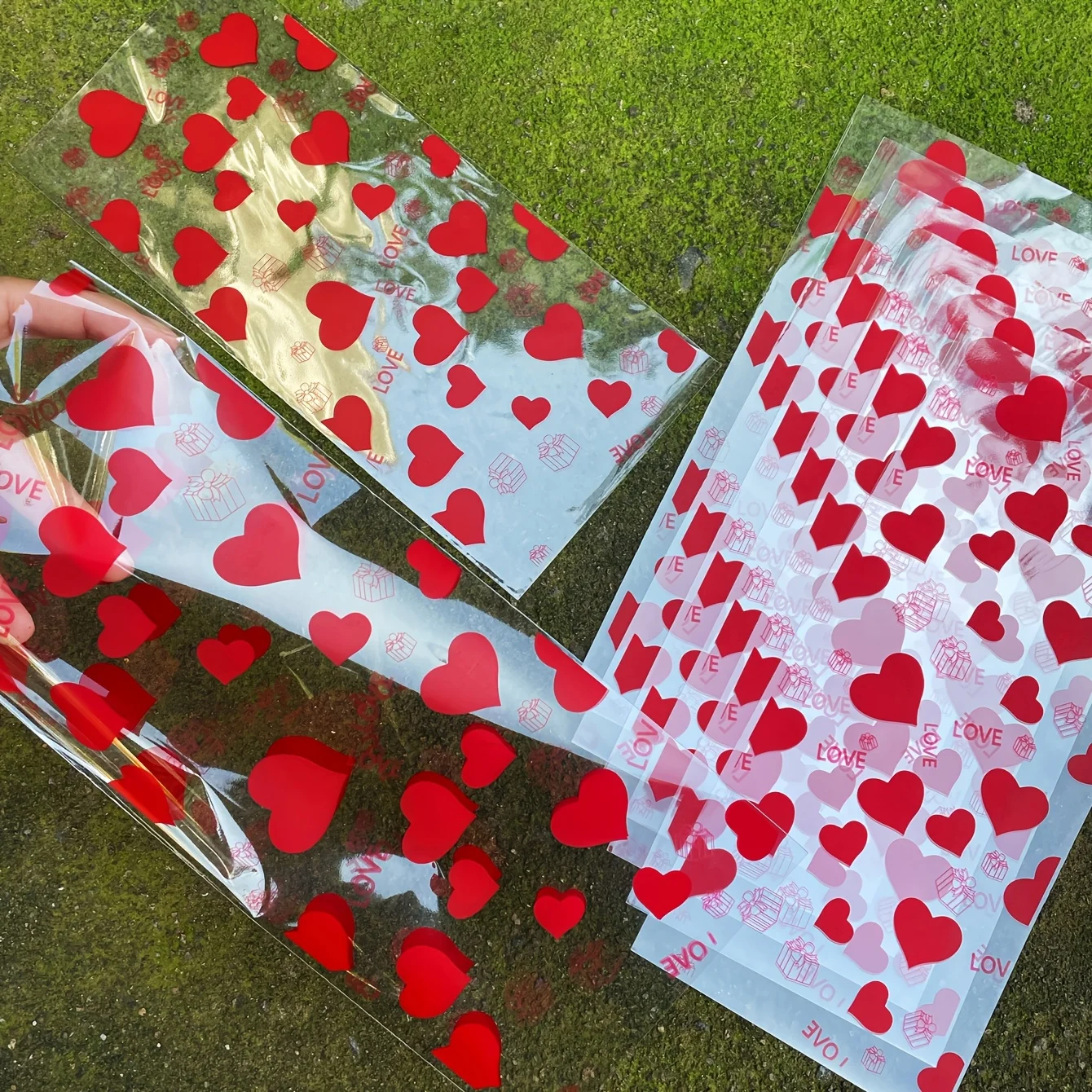 50 Stück rote Herz-LIEBE-bedruckte Geschenktüten mit goldenen Krawatten – transparente OPPE-Kunststoffbeutel für Valentinstag, romantische Paare Image